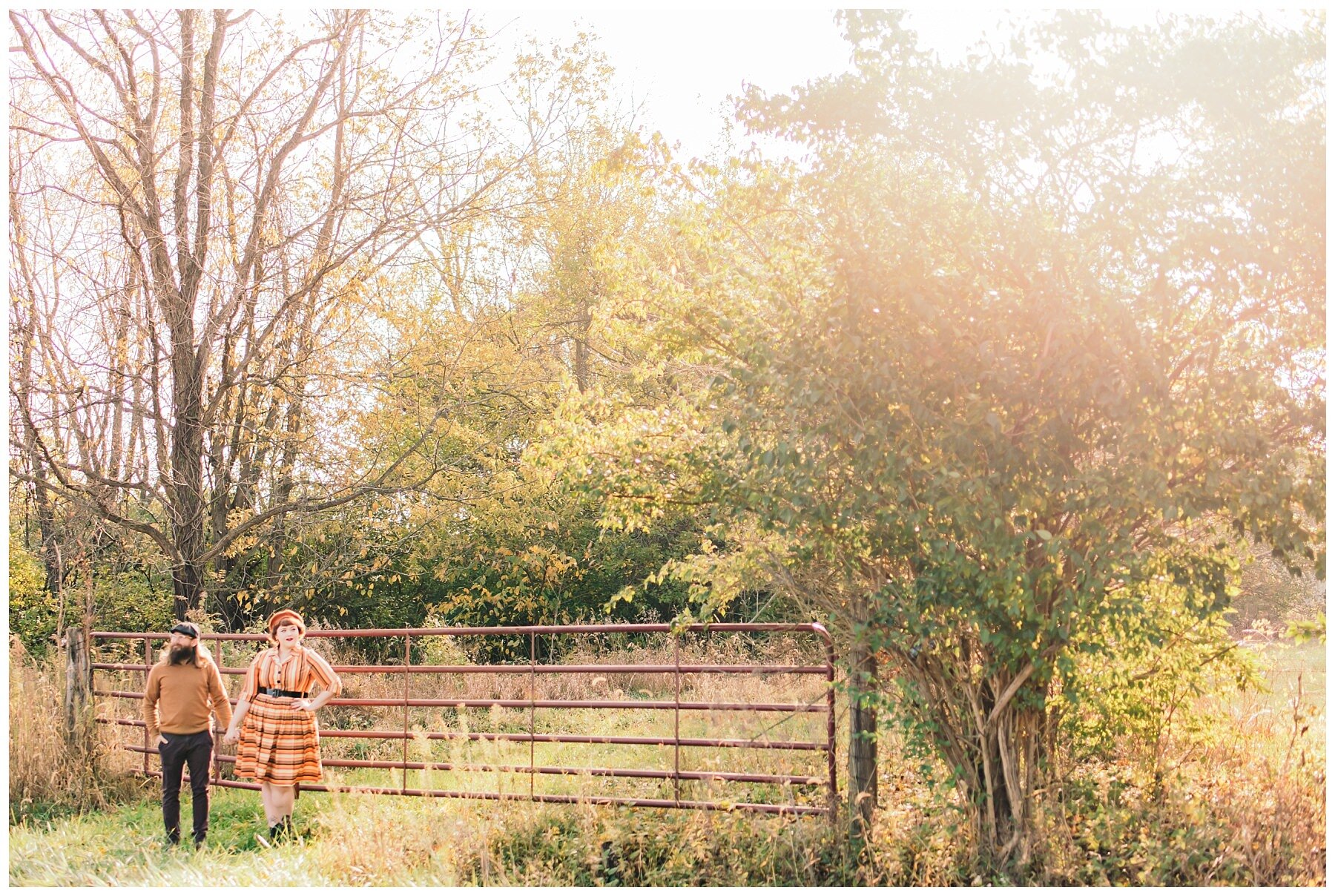 couple standing in front of a fence in the sunlight in the country