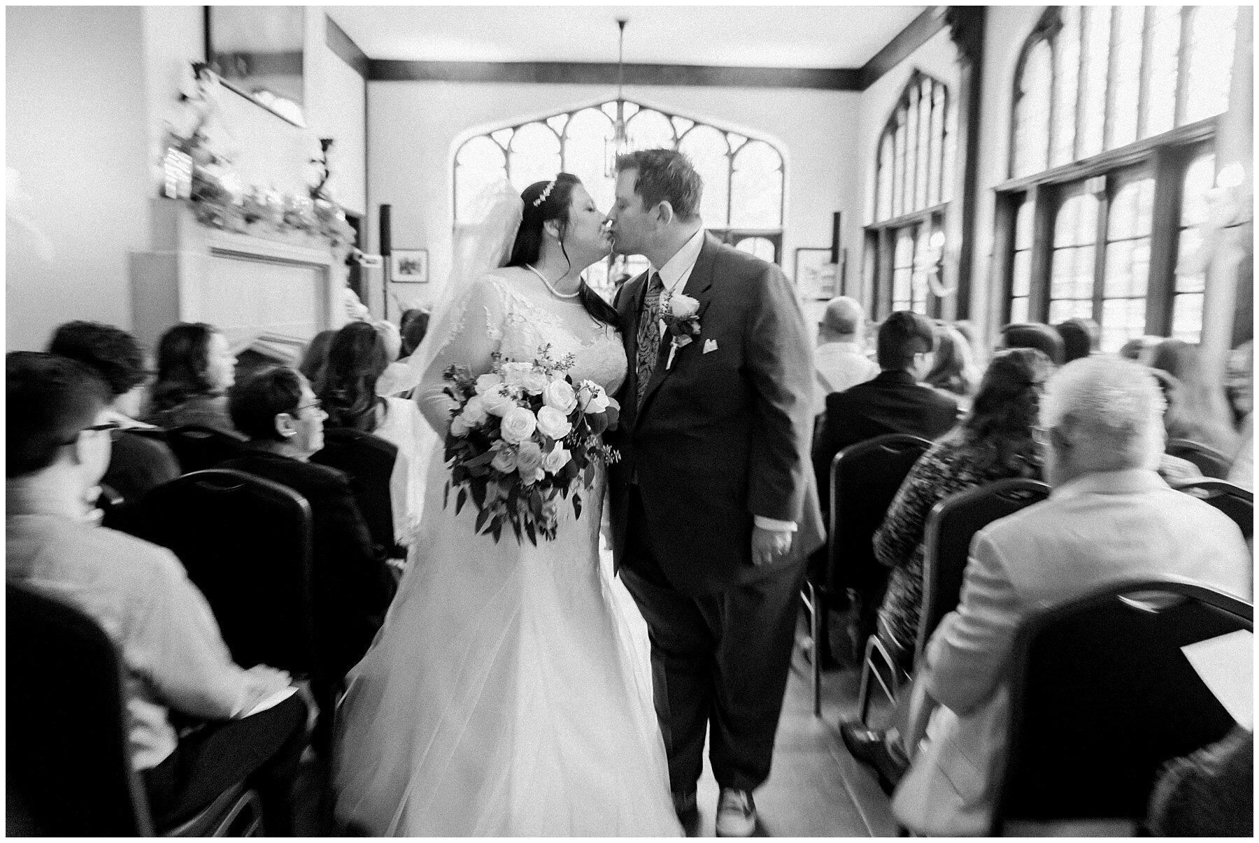black and white bride and groom kissing after exchanging vows at fowler house mansion