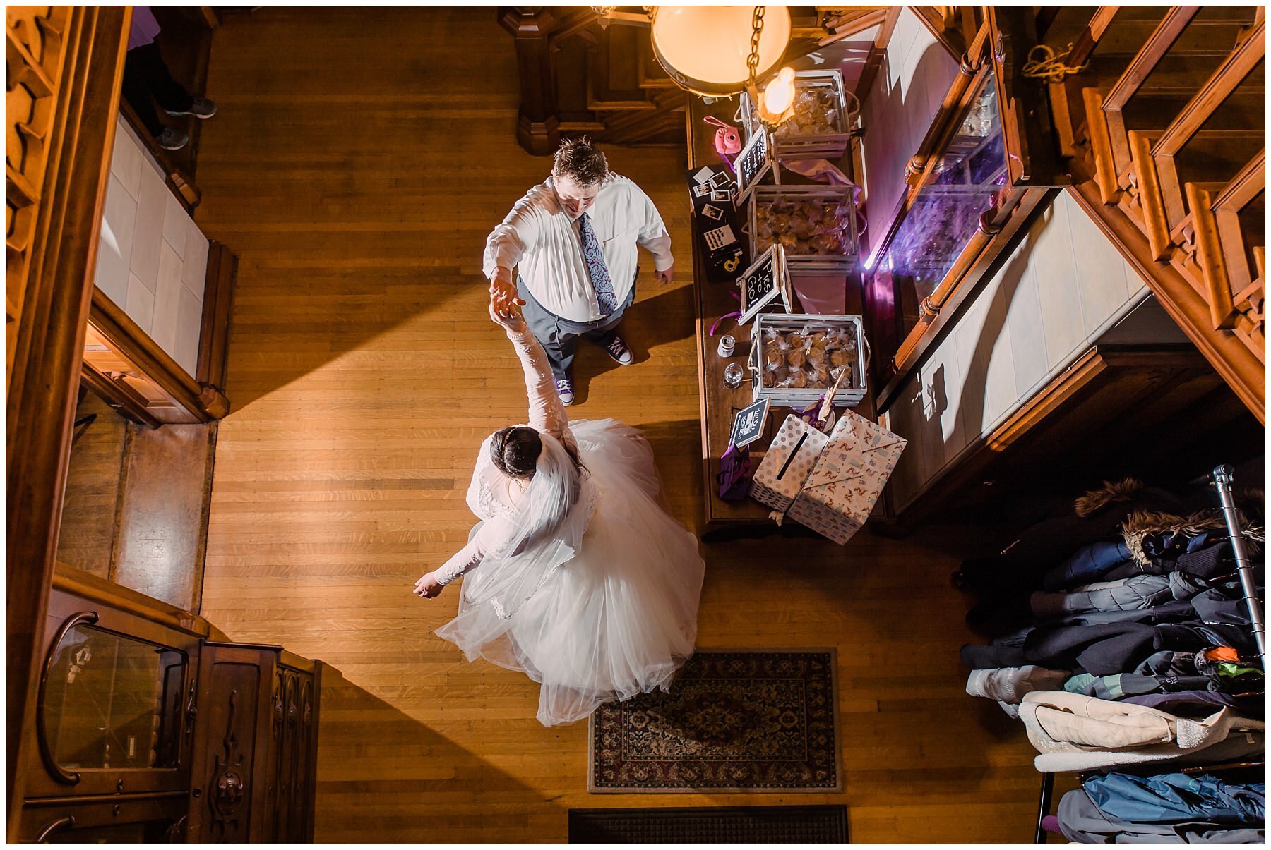 bride and groom dancing in a foyer at fowler house mansion with light shining in from their left 