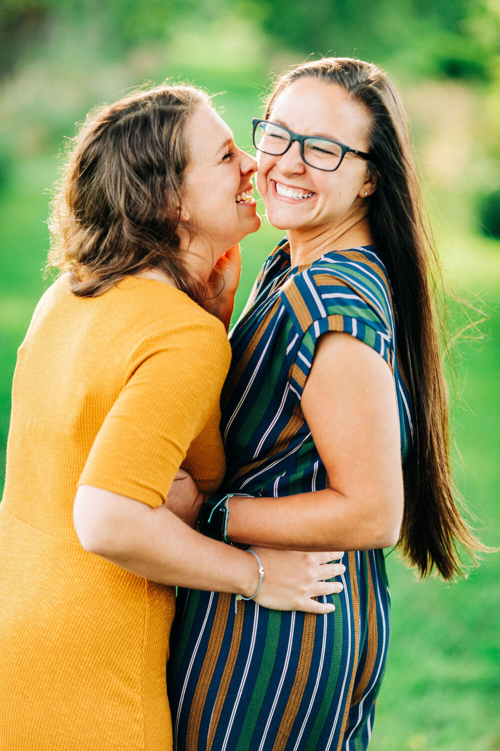 a lesbian couple laughing and smiling while embraced 