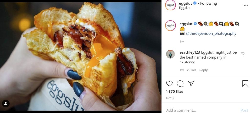 eggslut sandwich in hands of woman with painted nails