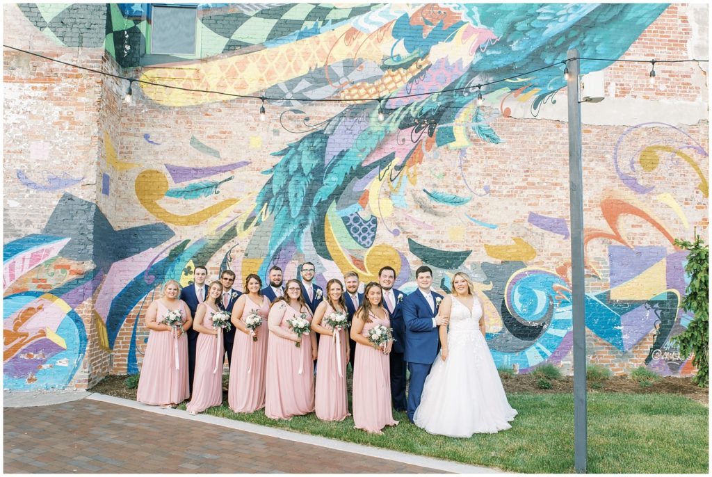 wedding party standing in front of a wall mural in rensselaer indiana