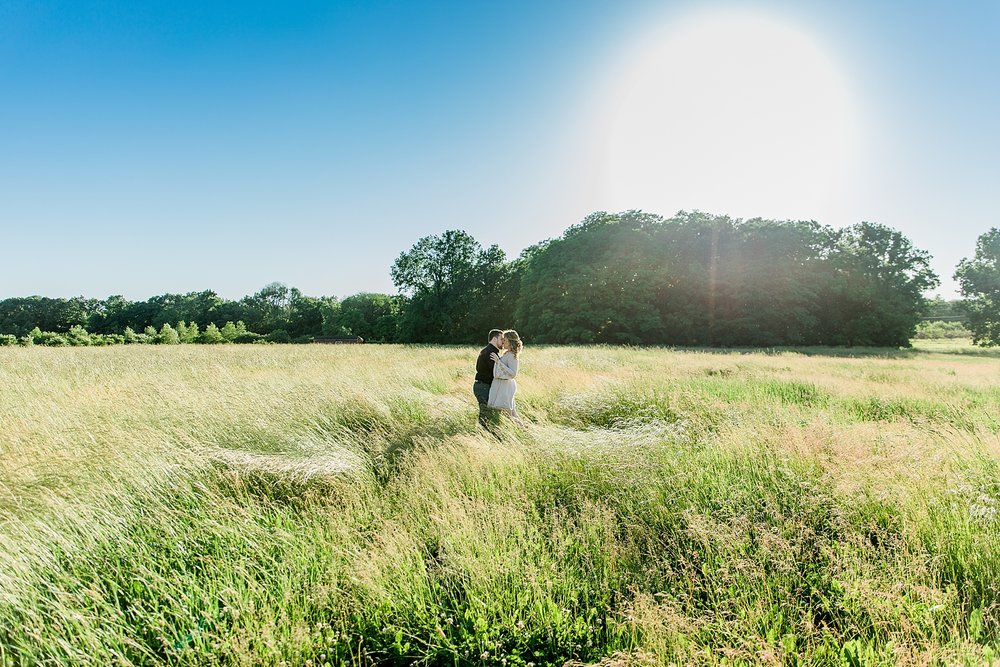 couple standing in a field kissing