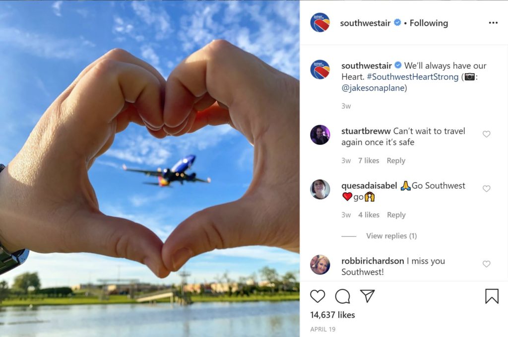 my favorite airline southwest flying in the sky with a heart shaped hands so you can see the airplane behind it