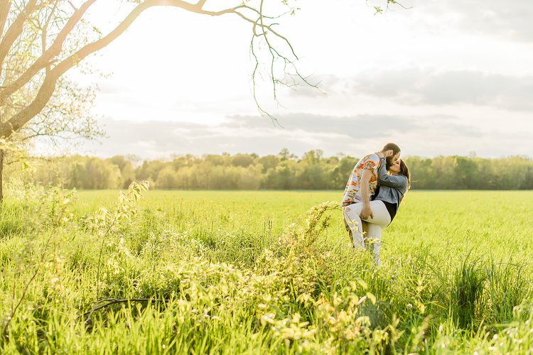 couple kissing dramatically in a field in the spring
