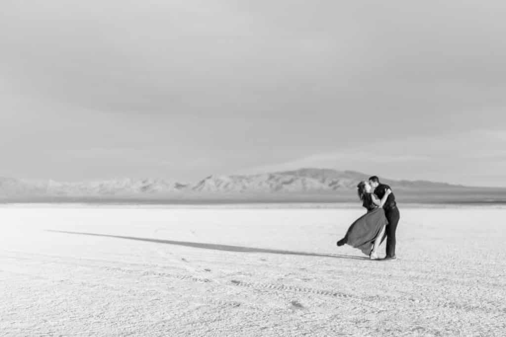 black and white image of couple standing in the desert