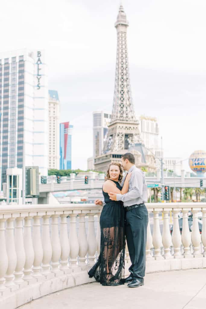 couple standing at caesars hotel in las vegas in front of eiffel tower