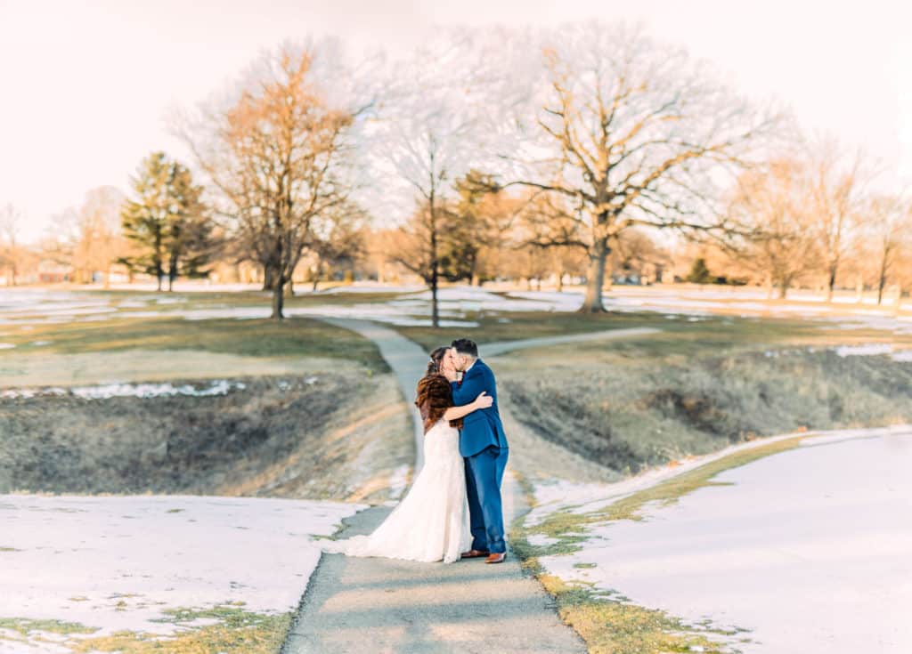 married couple kissing in snow at lafayette country club