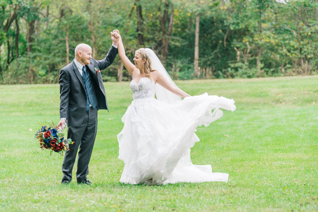 bride and groom dancing in field