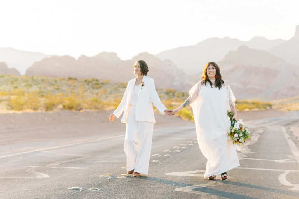 two brides walking down las vegas desert road