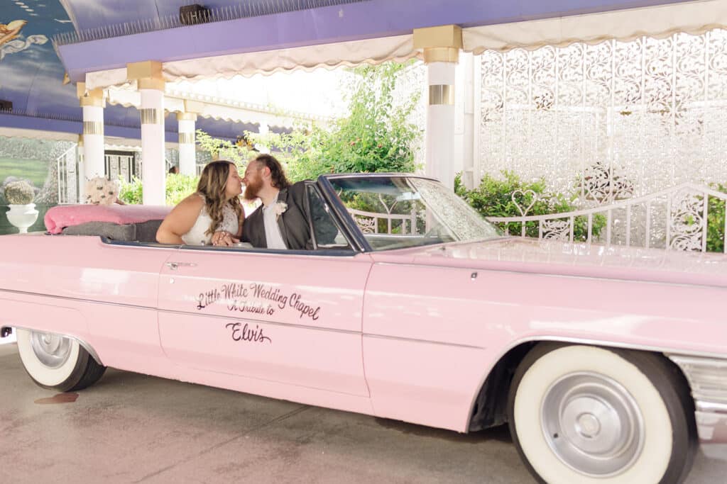 little white wedding chapel tunnel of love with pink cadillac with bride and groom